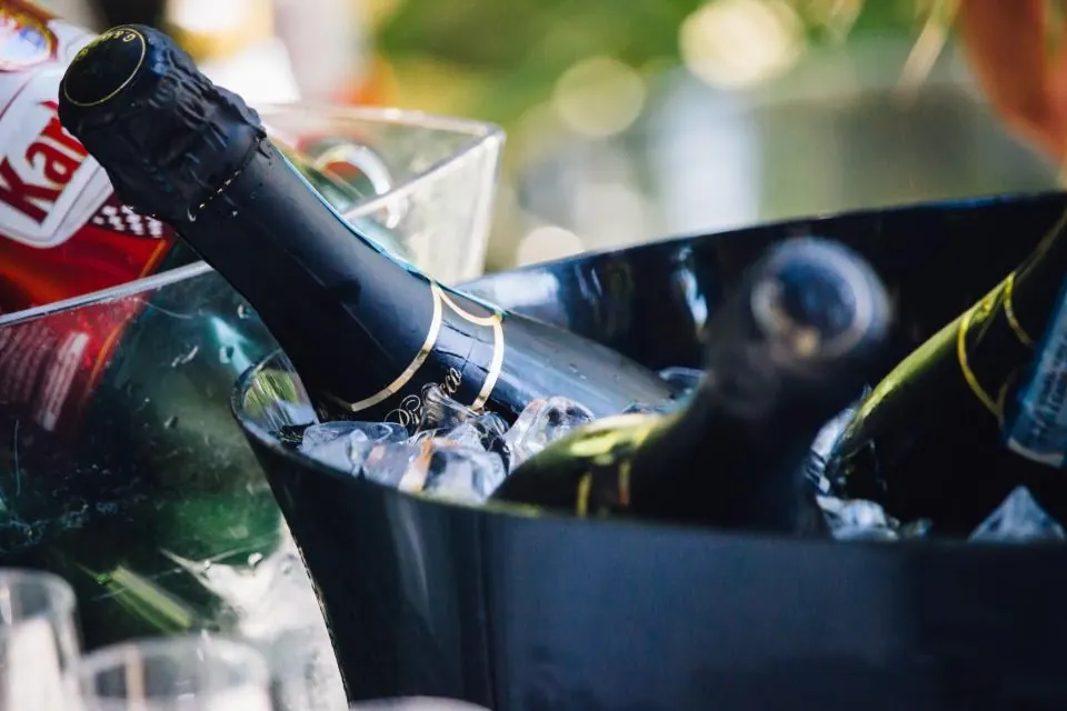 Botellas de cava enfriándose en una cubitera con hielo
