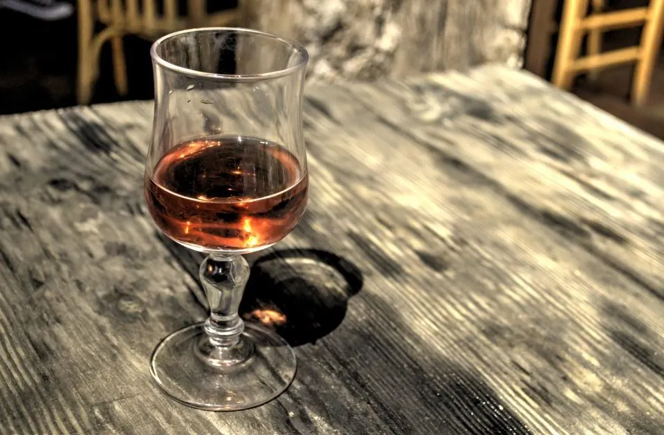 Copa de vino tinto sobre mesa rústica en una bodega de la Serranía de Ronda