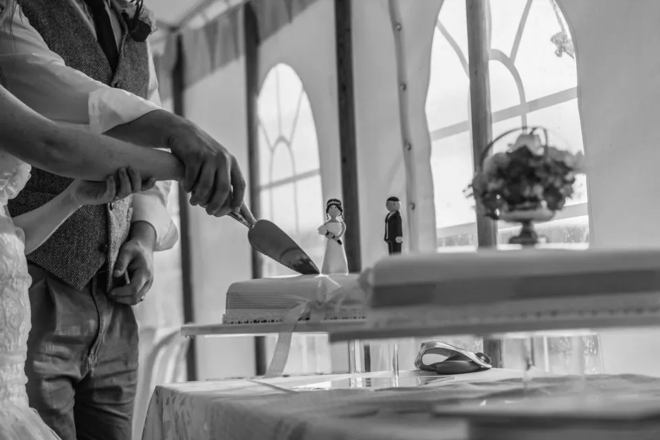 Novios cortando la tarta nupcial en una boda en Málaga, en blanco y negro