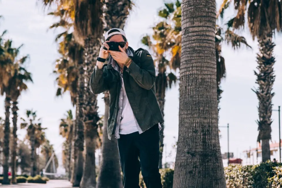 Fotógrafo durante una sesión de preboda en un paseo con palmeras de Málaga