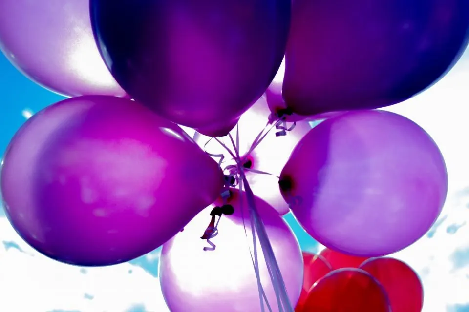 Globos morados elevándose al cielo en un cumpleaños en Málaga