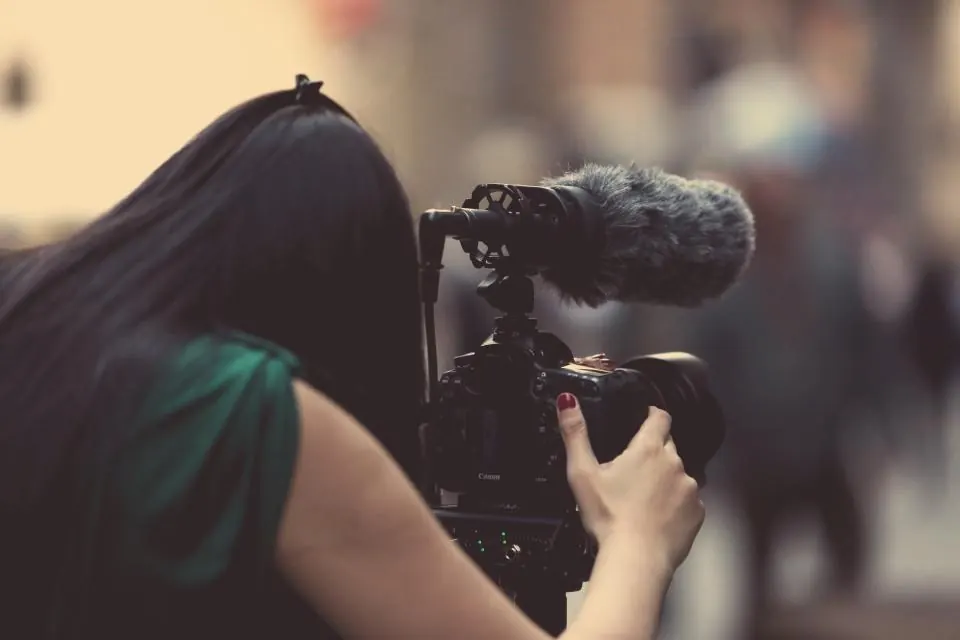 Videógrafa con cámara y micrófono grabando un evento en Málaga