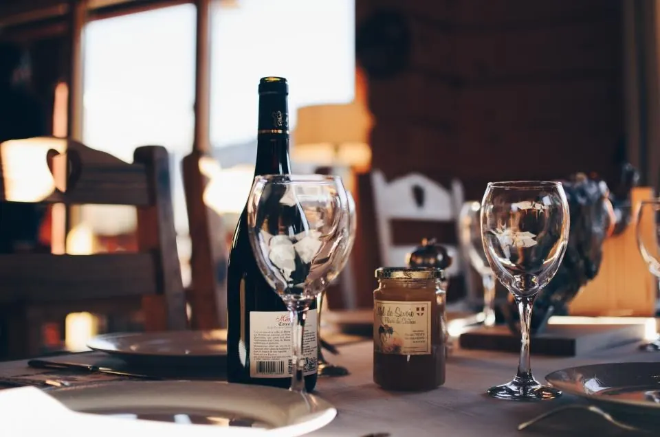 Botella y copas de vino de la Serranía en una mesa rústica de restaurante en Ronda